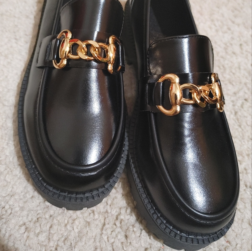 Black loafers with gold buckle.
